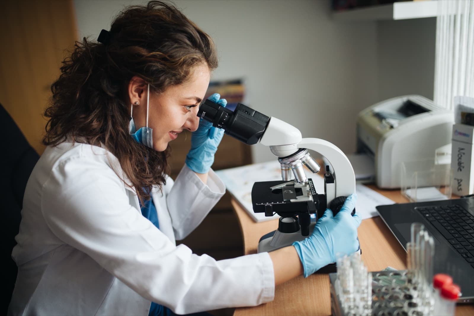 Researcher examining samples through a laboratory microscope