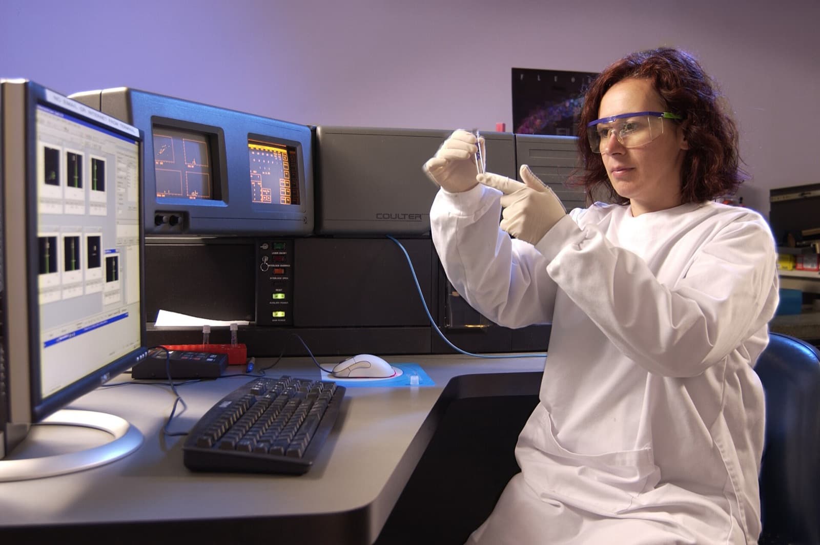 Scientist in a laboratory operating a flow cytometer for immune cell analysis