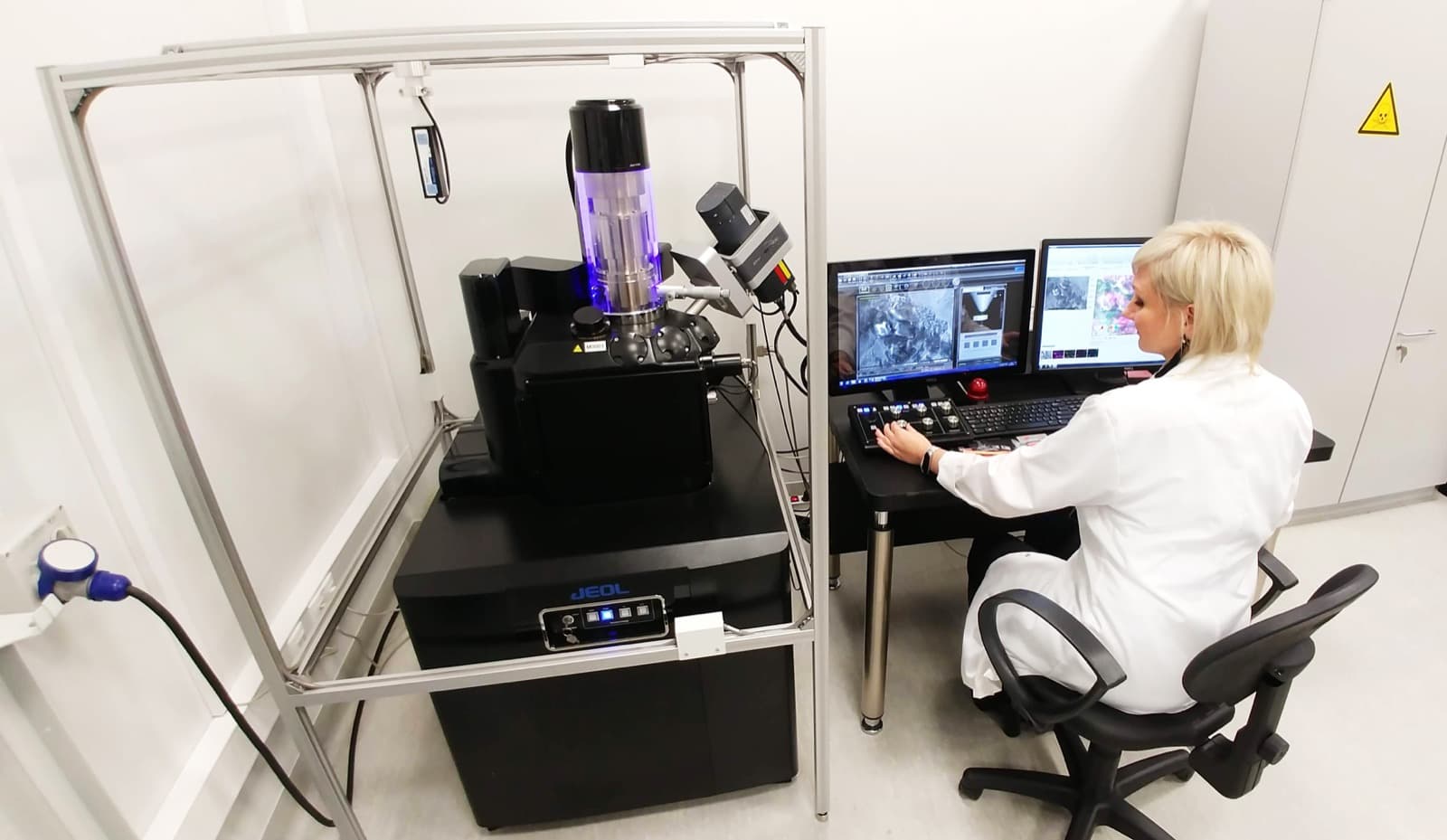 Scientist reviewing study data at an instrument workstation in a clean laboratory