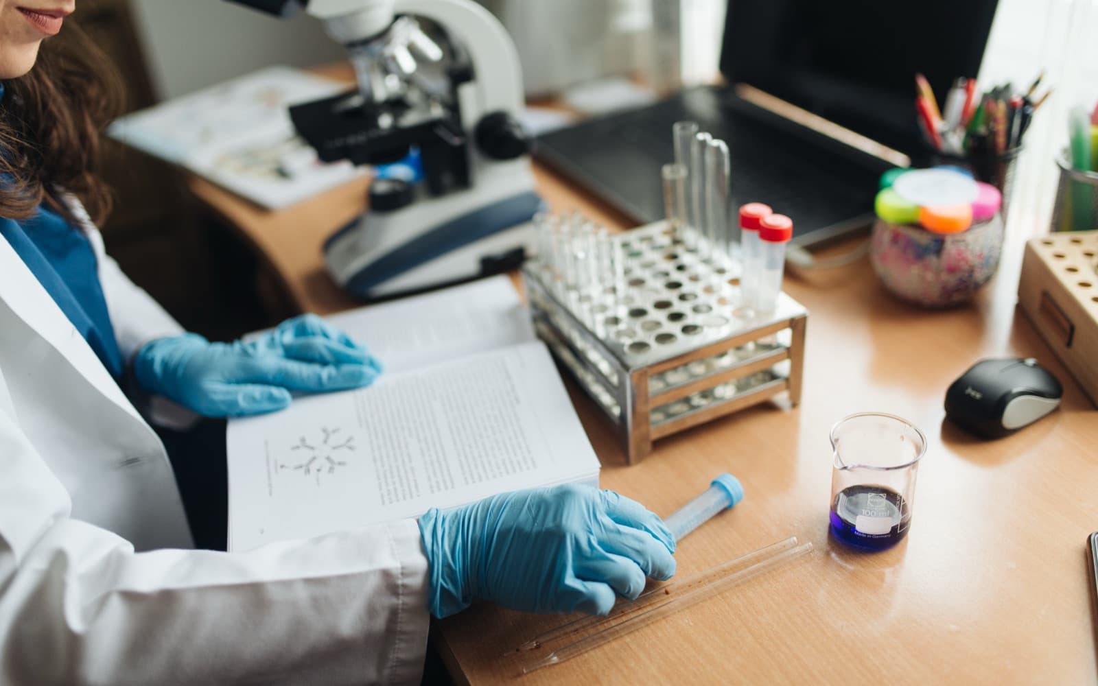 Chemist working with sample vials and reagents at a laboratory bench